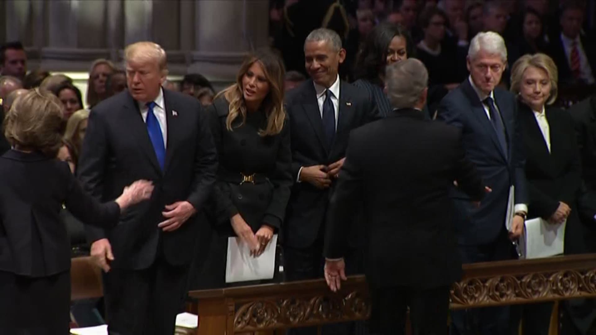 Former President George W. Bush greets his fellow presidents at his father's funeral and continued his tradition with Michelle Obama, slipping her a piece of candy