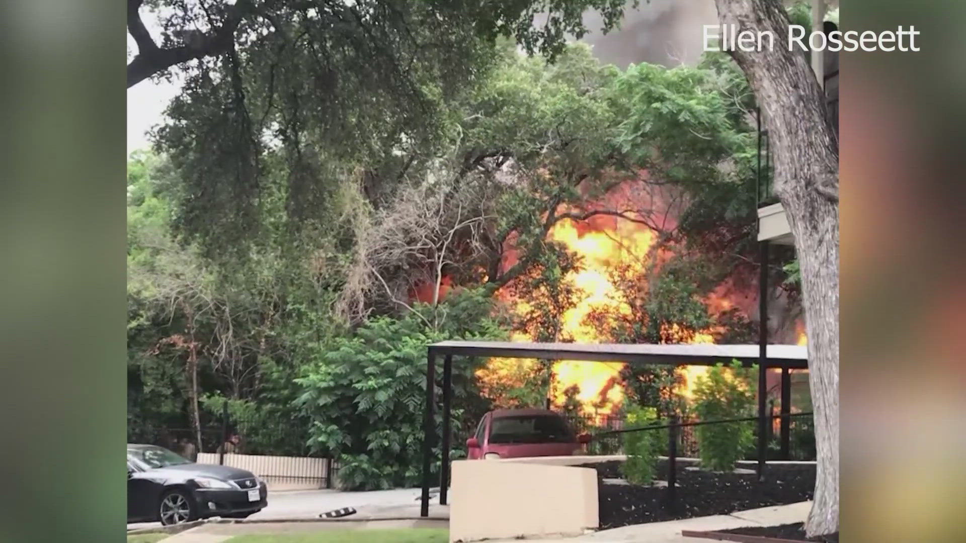 Large and tall flames can be seen coming from the structure that's nearby an apartment complex.