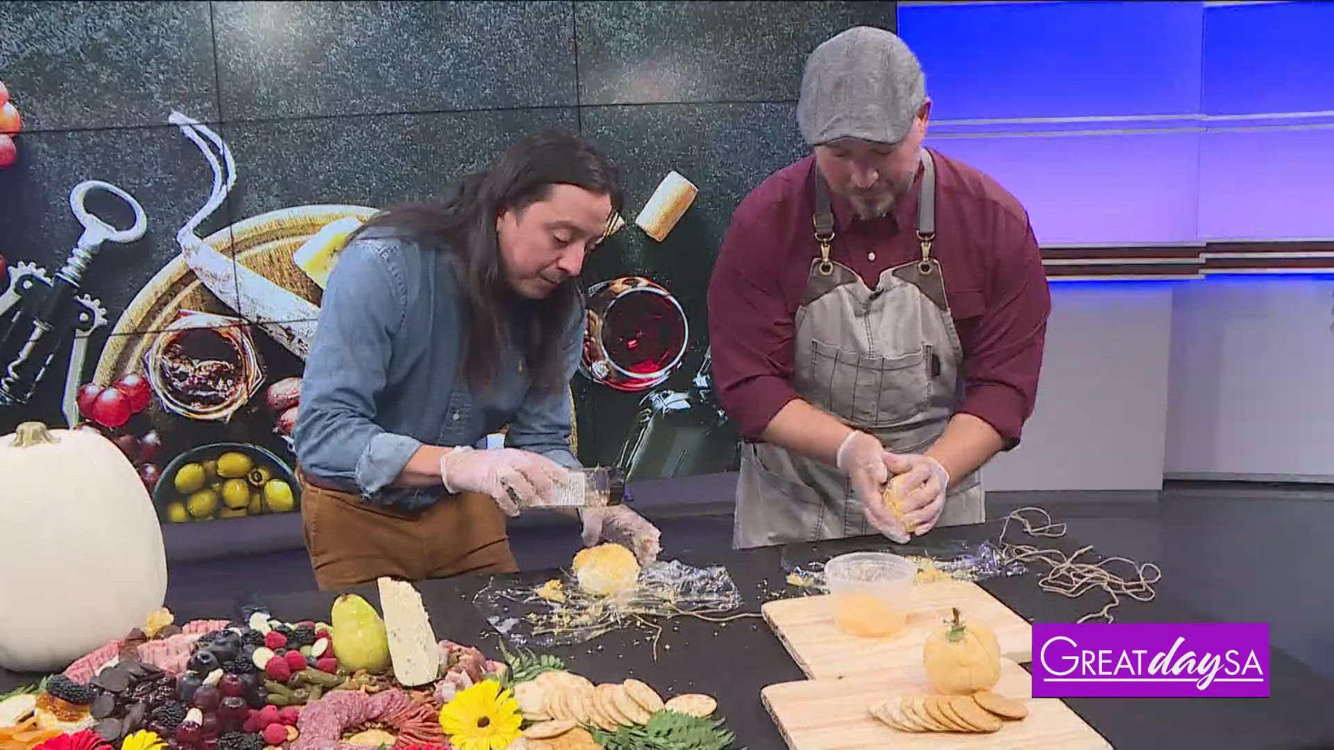 Multi-Skilled Journalist Justin Calderon helps Bryan Gonzales with The Board Couple make a pumpkin-shaped cheese ball. 