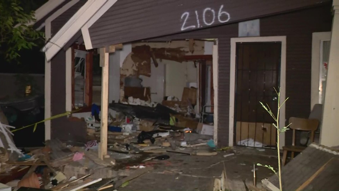 Woman injured after car crashes through home