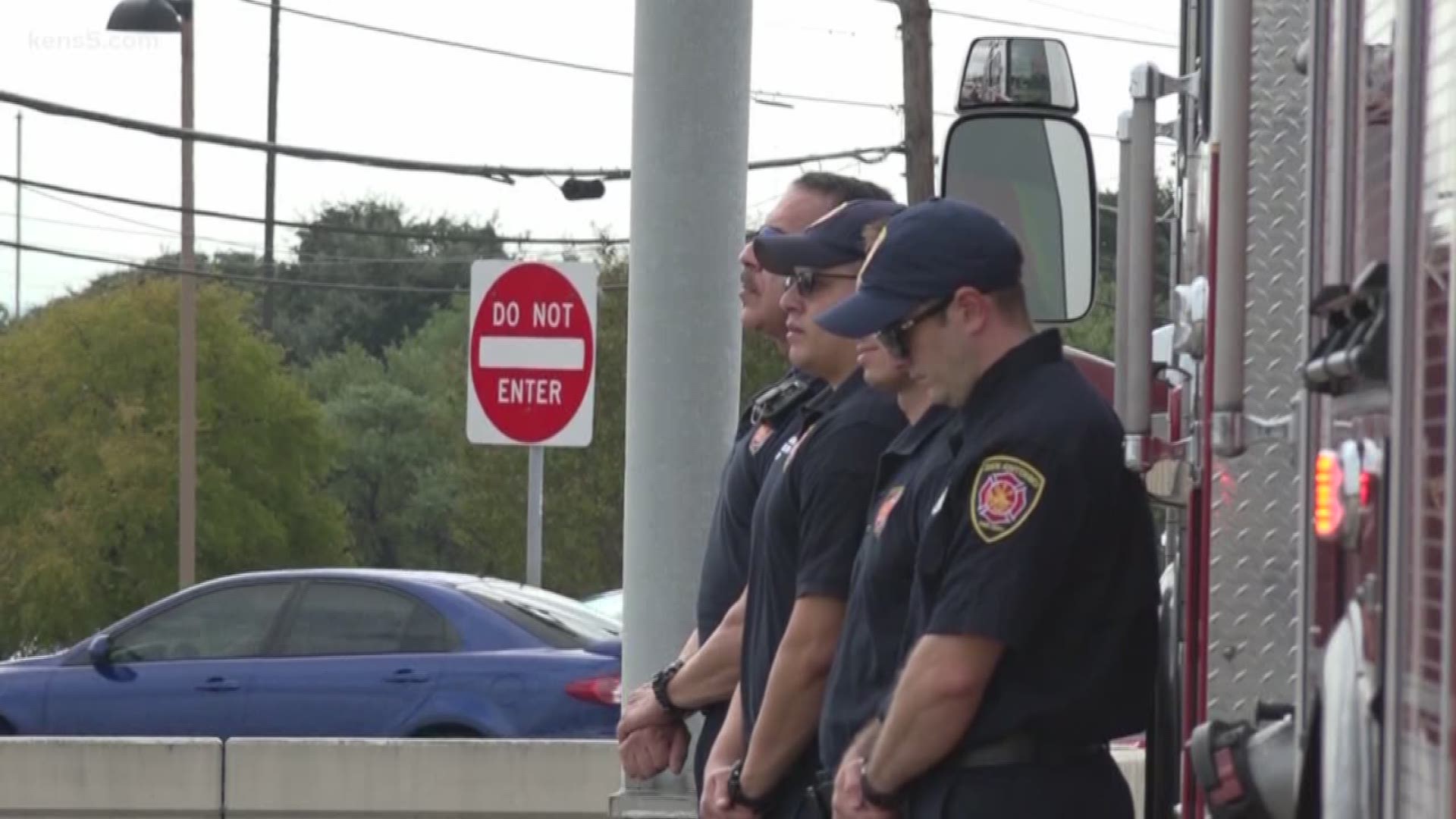 As police officers' flashing lights signaled that it was time to honor a fallen public servant, their fire-fighting comrades stood at attention on the overpass.