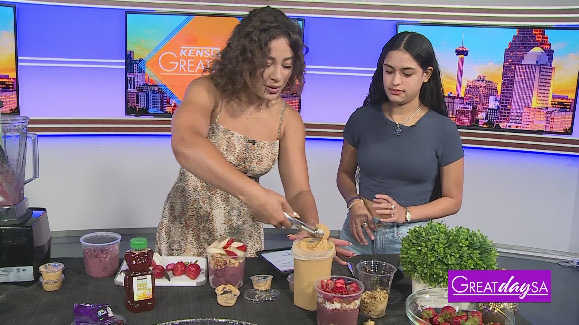 Clarke helps Maria G. with Rise Up make refreshing Açai Bowls.