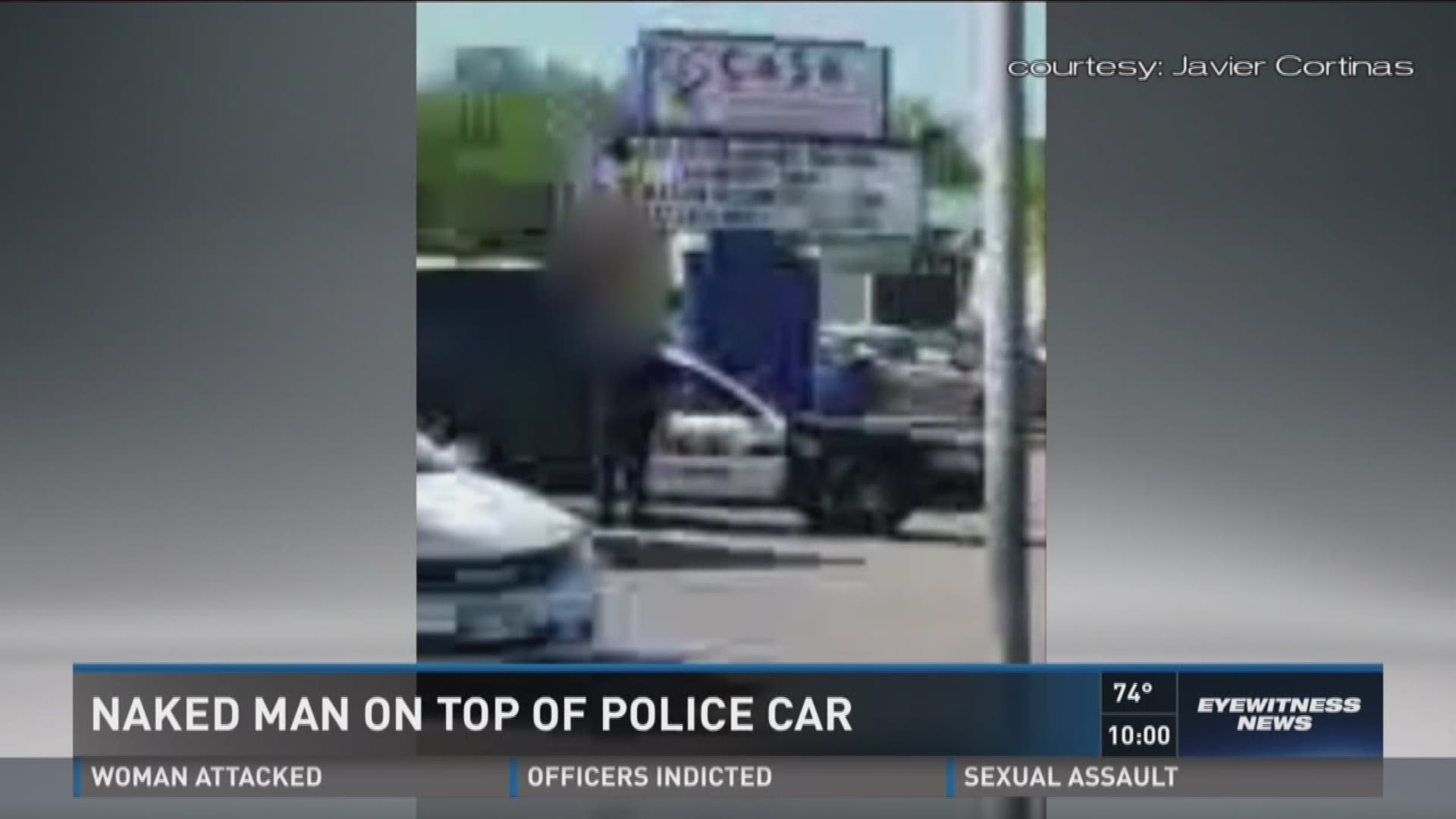 Naked man on top of police car