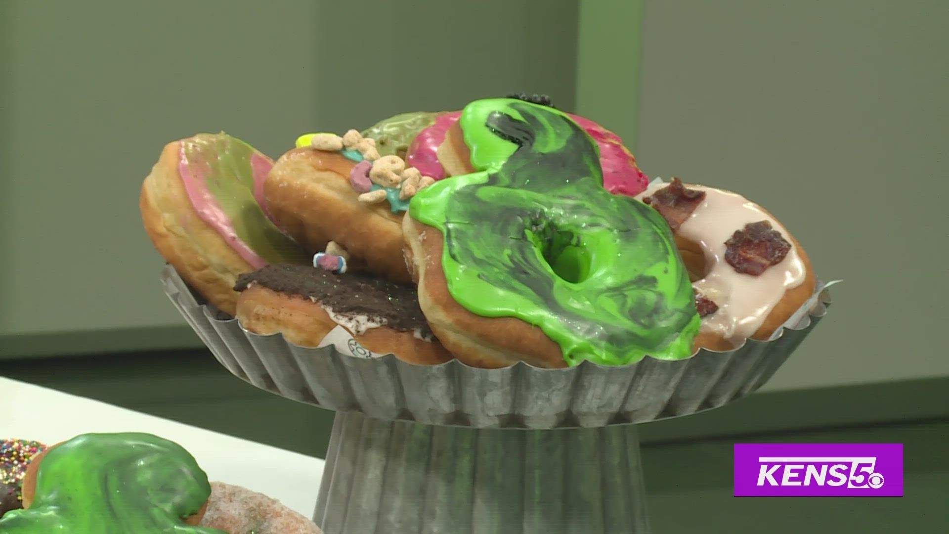 Andrea Aguirre with Art of Donut decorates a St. Patrick's Day-themed donut with Clarke.