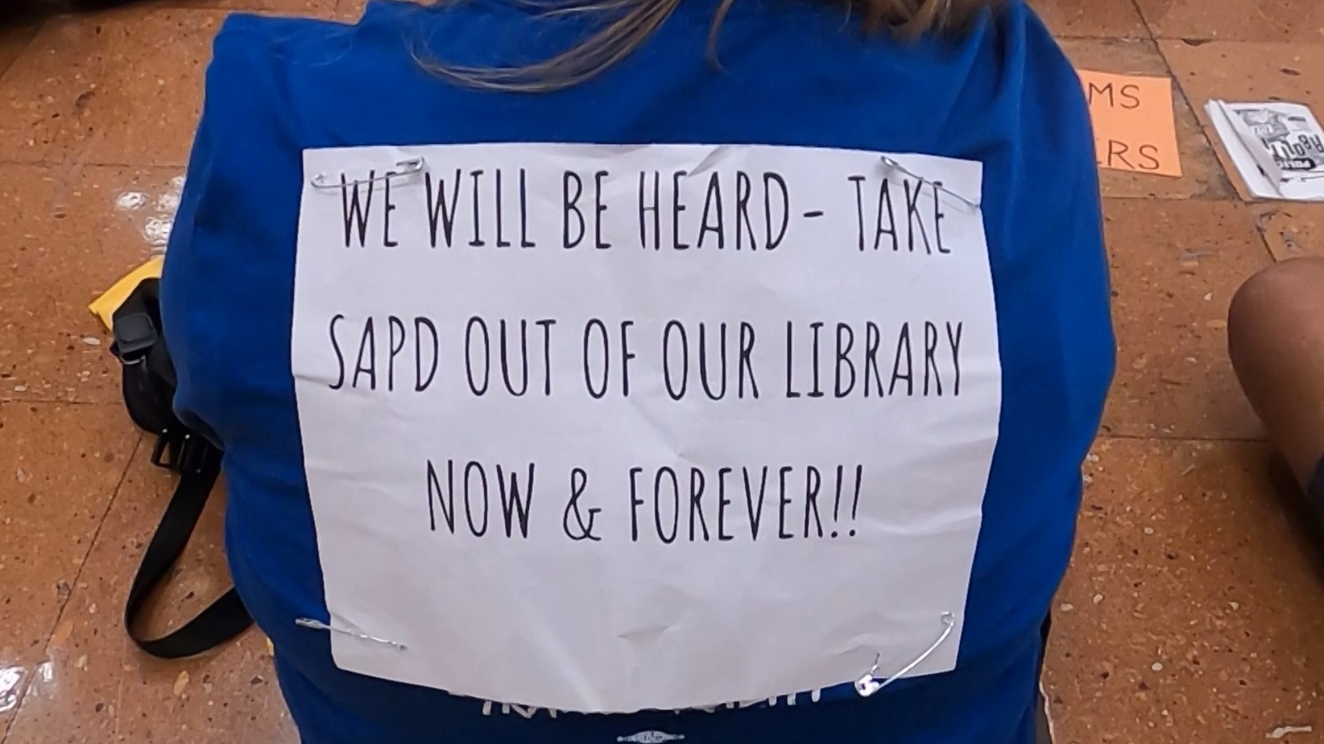After more than a dozen assaults at the downtown library, they added armed officers to combat the issue. But not everyone is on board with the idea.