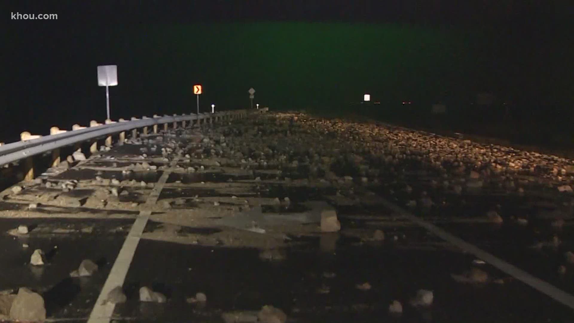 The highway to and from Bolivar Peninsula is impassable after waves push rocks along the road.