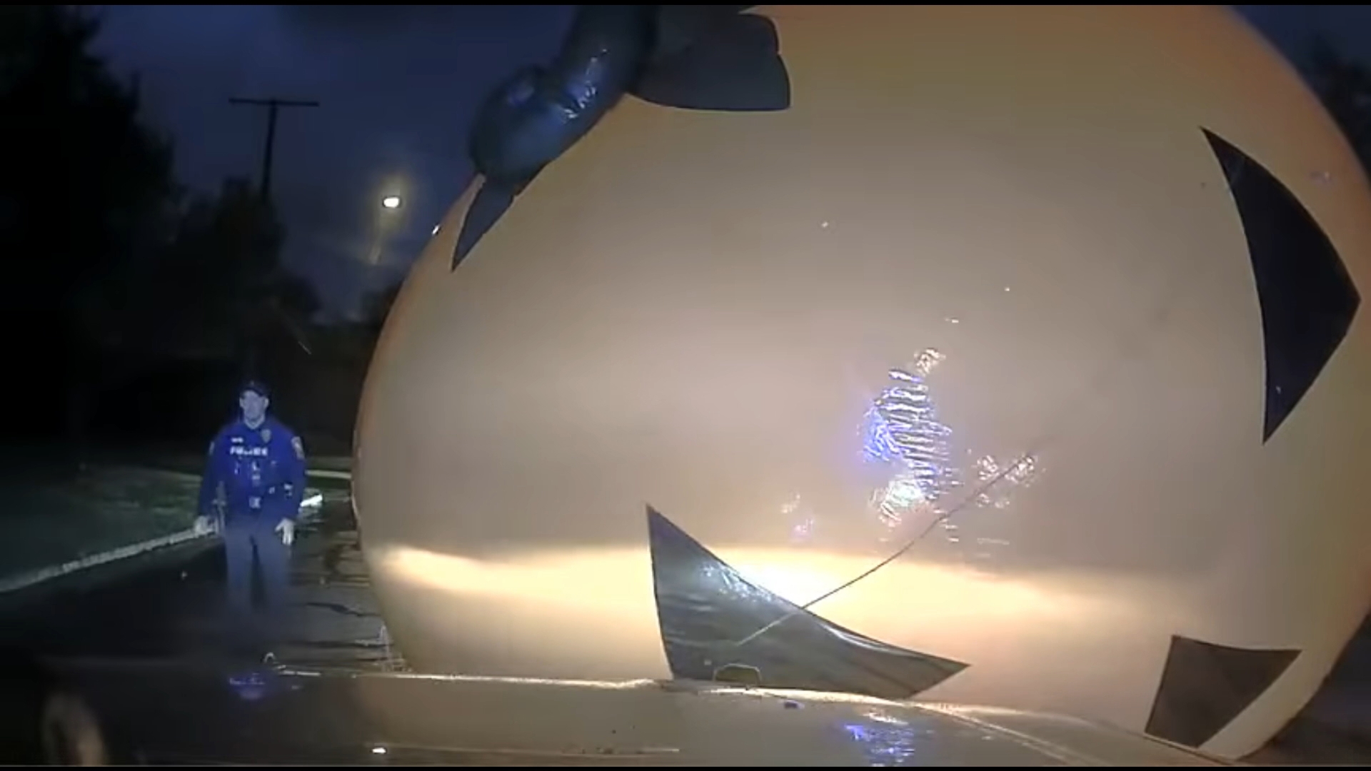 Dashcam video from a police department in northeast Ohio shows an officer struggling to wrangle a giant inflatable pumpkin off the roadway after it blew away.