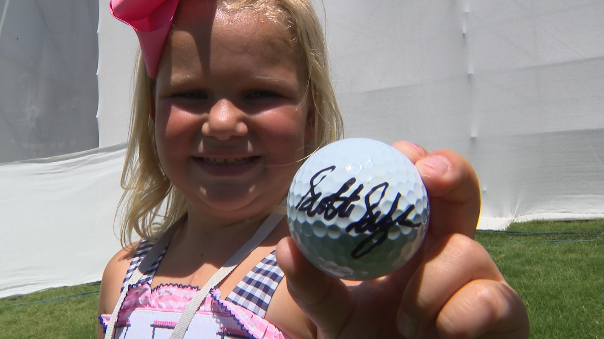 Six-year-old Charlotte Berlau fulfills her wish to meet golfer Scottie Scheffler, walking alongside him at the Charles Schwab Challenge after battling heart disease.