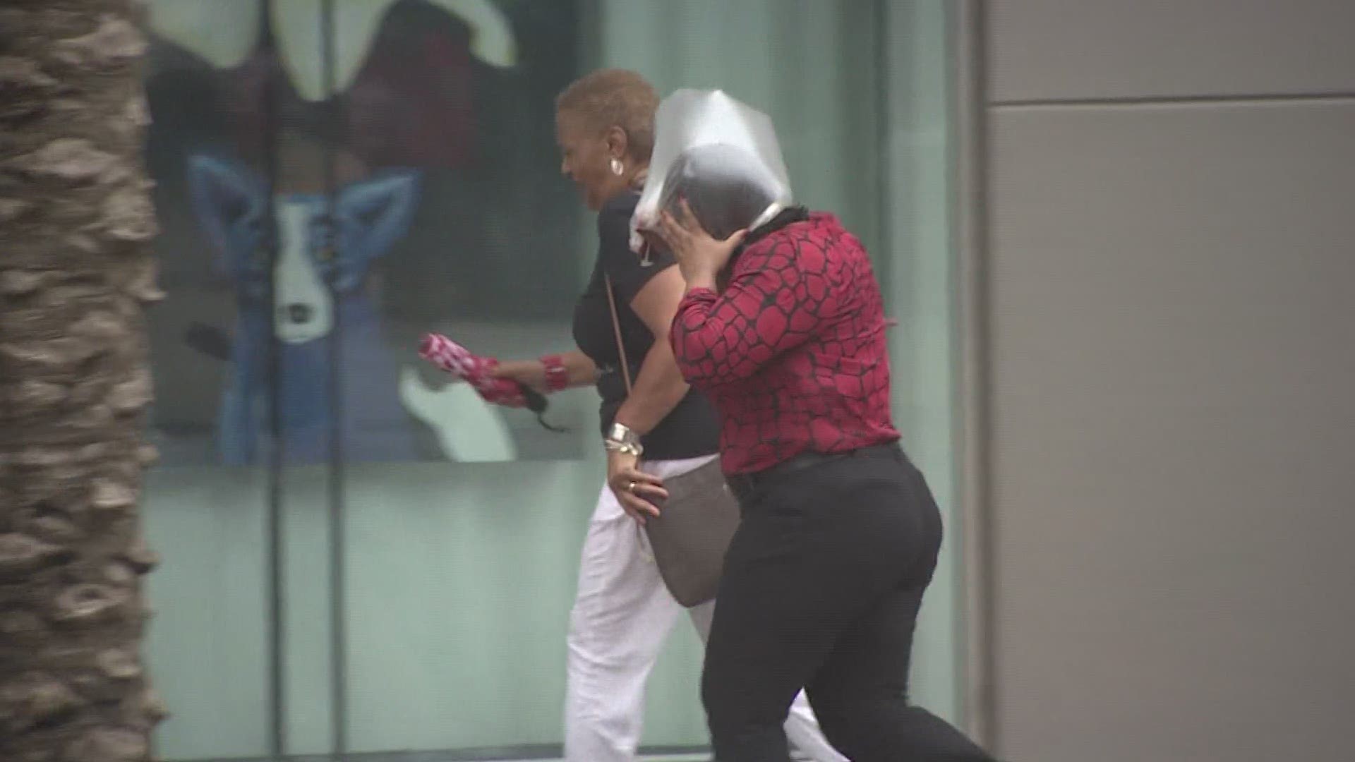 Pedestrians fight the wind on Canal Street ahead of Tropical Storm Barry