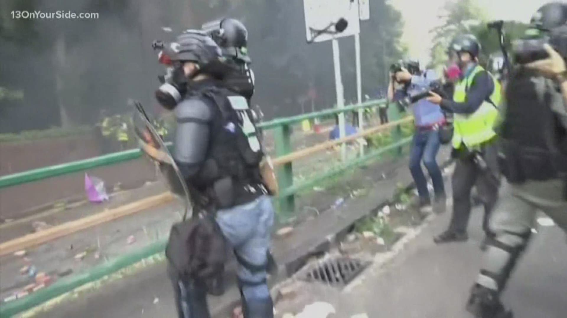 Hong Kong police using tear gas and batons fought off protesters Monday as they tried to break through a police cordon that is trapping hundreds on a university.